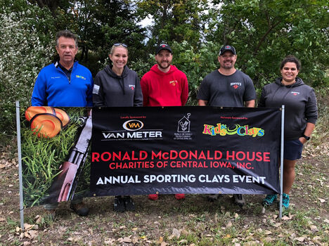 Small group of people standing behind a banner at an event